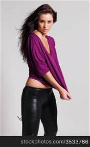 Beautiful tall brunette in a purple tee and black leather pants