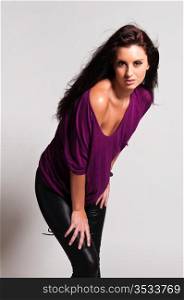 Beautiful tall brunette in a purple tee and black leather pants