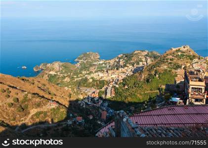 Beautiful Taormina sea coast panoramic view from Castelmola mountain village and Castelmola roofs, Sicily, Italy. People unrecognizable.