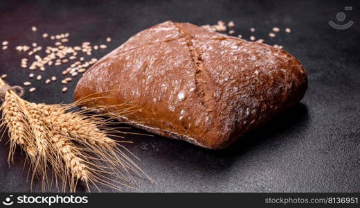 Beautiful tasty, square-shaped brown bread on a dark concrete background. Baking bread at home. Beautiful tasty, square-shaped brown bread on a dark concrete background