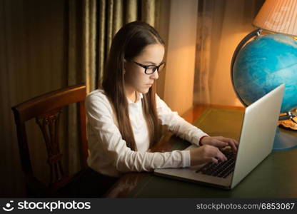 Beautiful teen girl doing homework with laptop