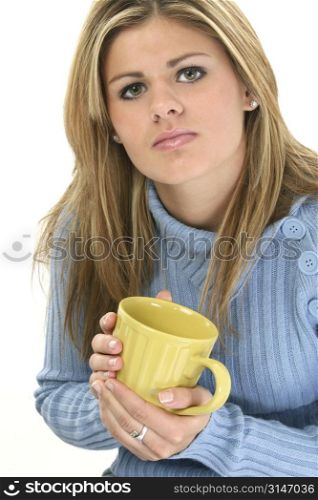 Beautiful teen girl in blue sweater with coffee mug. Shot in studio over whte.