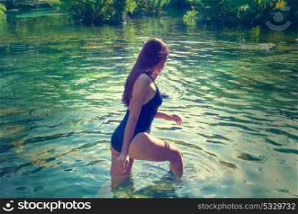 Beautiful teen girl in cenote of Riviera Maya with swimsuit