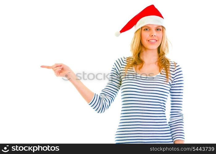 Beautiful teen girl in Santa hat pointing in corner isolated on white &#xA;