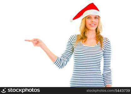 Beautiful teen girl in Santa hat pointing in corner isolated on white &#xA;