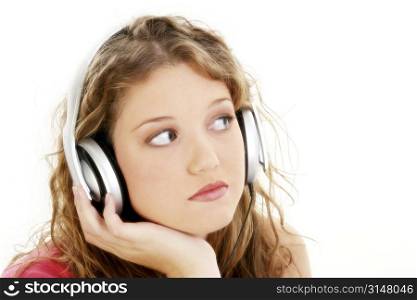 Beautiful Teen Girl Listening To Headphones. Long curly blonde hair. Casual wear.