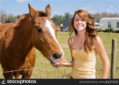Beautiful teen girl on the farm with her horse.