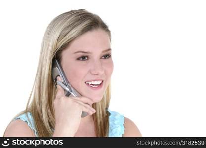 Beautiful teen girl over white background talking on cellphone.