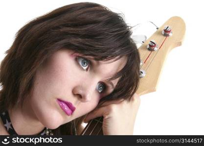 Beautiful teen girl resting on headstock of bass electric.