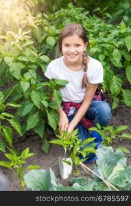 Beautiful teenage girl working at garden with hand shovel