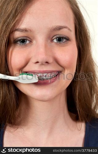 Beautiful teenage woman practicing good oral dental care by brushing her teeth