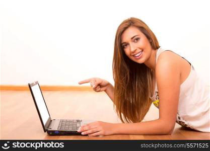 Beautiful teenager relaxing at her living room with the company of a last generation computer
