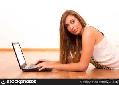 Beautiful teenager relaxing at her living room with the company of a last generation computer