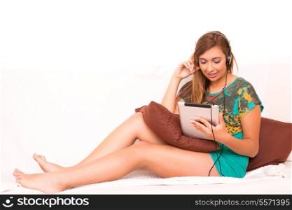 Beautiful teenager relaxing on the couch with the company of a last generation tablet computer