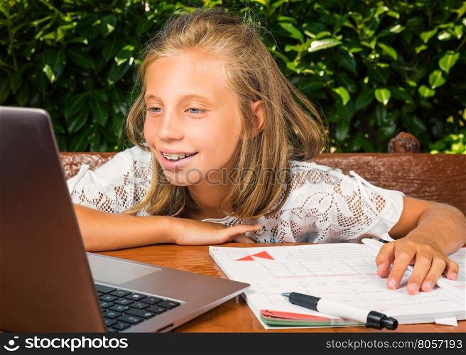 Beautiful teenager student, 10 years old,happiness studying on the computer.