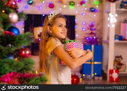 Beautiful ten-year-old girl hugged a gift