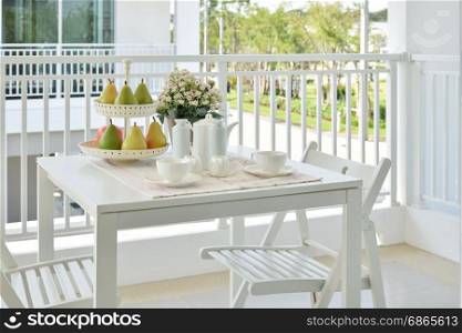 beautiful terrace with white furniture and tea or coffee set at home