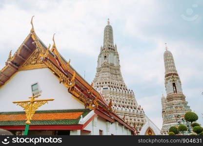 Beautiful Thai style temple roof with a view of prang pagoda ancient architecture at Wat Arun. Bangkok, Thailand.