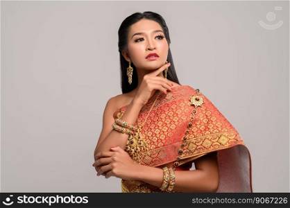 Beautiful Thai woman wearing Thai dress and looking at the top