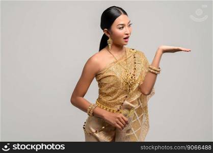 Beautiful Thai women wear Thai clothes and open his hand to the left