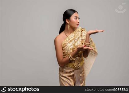 Beautiful Thai women wear Thai clothes and open his hand to the left