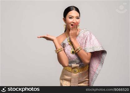 Beautiful Thai women wear Thai clothes and open his hand to the right
