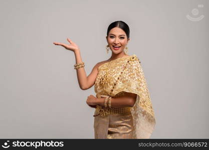 Beautiful Thai women wear Thai clothes and open his hand to the right