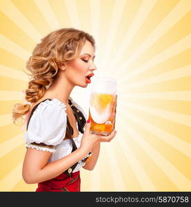 Beautiful thirsty sexy woman wearing red jumper shorts with suspenders as traditional dirndl, drinking from a beer mug on colorful abstract cartoon style background. Side view.