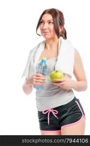 beautiful thoughtful girl holding an apple and a bottle of water