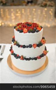 Beautiful three-tiered cake decorated with colorful flowers.. A huge cake for the guests of the holiday for the wedding 2176.
