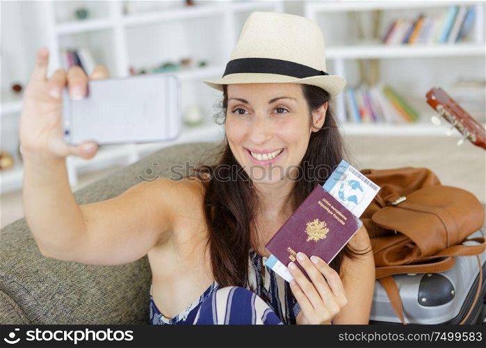 beautiful tourist woman taking funny selfie with passport