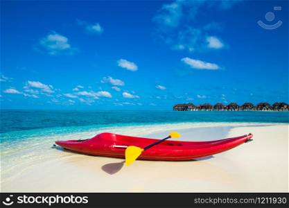 Beautiful tropical beach with white sand, turquoise ocean water and blue sky at exotic island. Kayaks on the tropical beach