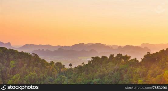 Beautiful tropical landscape with mountain rainforest and steep rocky ridge at horizon at sunset. Krabi, Thailand