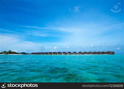 Beautiful tropical Maldives island with beach. Sea with water bungalows