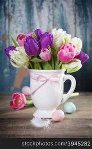 Beautiful tulips bouquet and easter eggs on wooden table - spring, easter or gardening concept