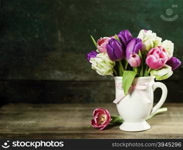 Beautiful tulips bouquet on old wooden table