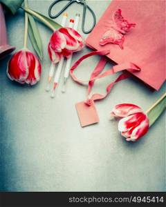 Beautiful tulips flowers, markers and paper shopping bag, top view, copy space. Abstract greeting concept