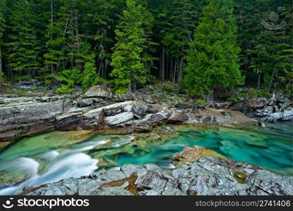 Beautiful turquoise blue water flowing in McDonald Creek in Glacier National Park, Montana, USA.