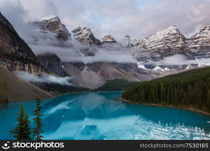 Beautiful turquoise waters of the Moraine lake with snow-covered peaks above it in Banff National Park of Canada