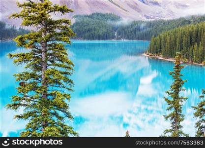 Beautiful turquoise waters of the Moraine lake with snow-covered peaks above it in Banff National Park of Canada