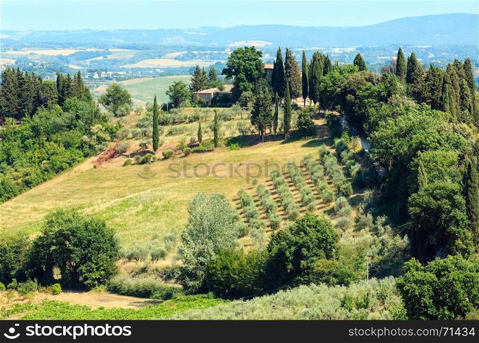 Beautiful Tuscany summer countryside landscape from San Gimignano town walls. Typical for the Italy region Toscana farm houses, hills, wheat field, olives garden, vineyards, cypress passes.