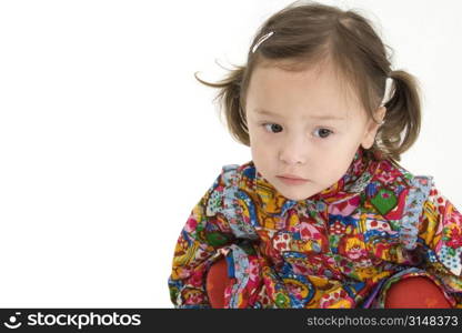 Beautiful two year old Japanese American girl in bright colorful outfit. Serious expression.