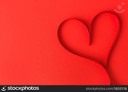Beautiful valentines day heart shape made from ribbon on red background. View from above. Valentines Day Concept. 
