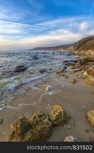 Beautiful vertical view of the coastline with stones on the sand