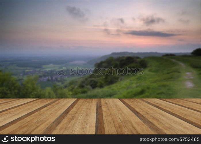 Beautiful vibrant sunrise over rolling countryside landscape with wooden planks floor