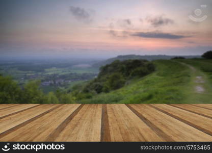 Beautiful vibrant sunrise over rolling countryside landscape with wooden planks floor