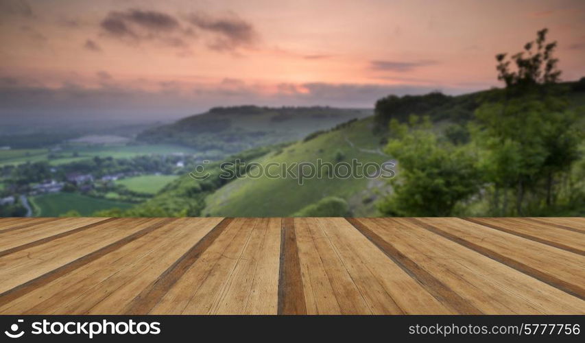 Beautiful vibrant sunrise over rolling countryside landscape with wooden planks floor