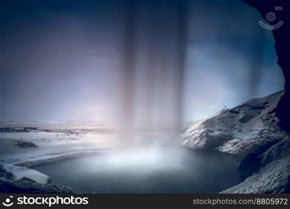 Beautiful View from inside of Seljalandsfoss Waterfall. Powerful Stream of the River. Amazing Winter Landscape. Famous Tourists Attraction of Iceland.. Waterfall in Iceland