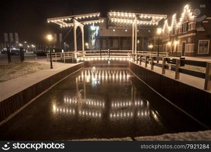 Beautiful view of drawbridge reflecting in water at winter night
