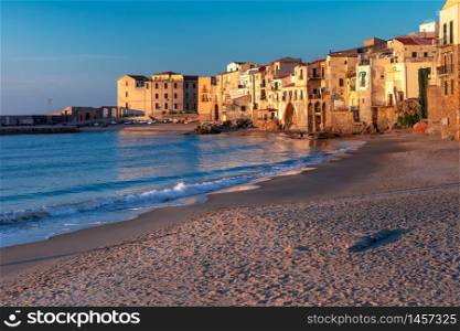 Beautiful view of empty sunny sand beach and old town of coastal city Cefalu at sunset, Sicily, Italy. Cefalu at sunset, Sicily, Italy
